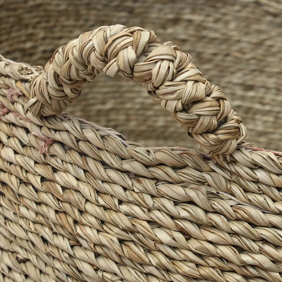 Close-up van het handvat van de Cuatro Manos Mand Zeegras, zorgvuldig gevlochten voor extra stevigheid en comfort bij het dragen.