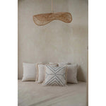 Loom Rotan Hanglamp in boho-stijl boven een comfortabele zithoek, een perfecte toevoeging voor een warme sfeer.