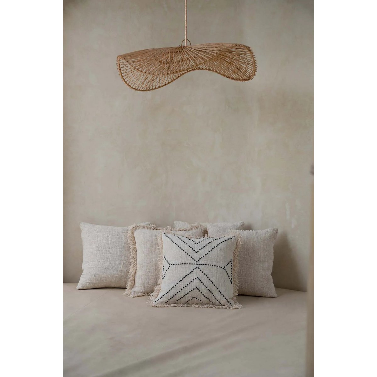 Loom Rotan Hanglamp in boho-stijl boven een comfortabele zithoek, een perfecte toevoeging voor een warme sfeer.
