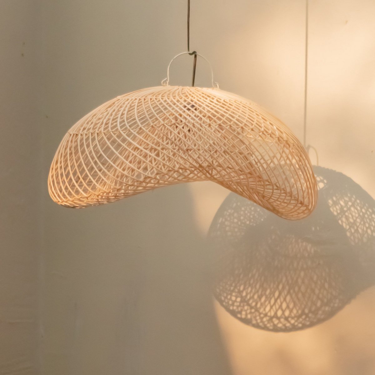 Aruna rotan hanglamp werpt zachte patronen op de muur voor een warme sfeer