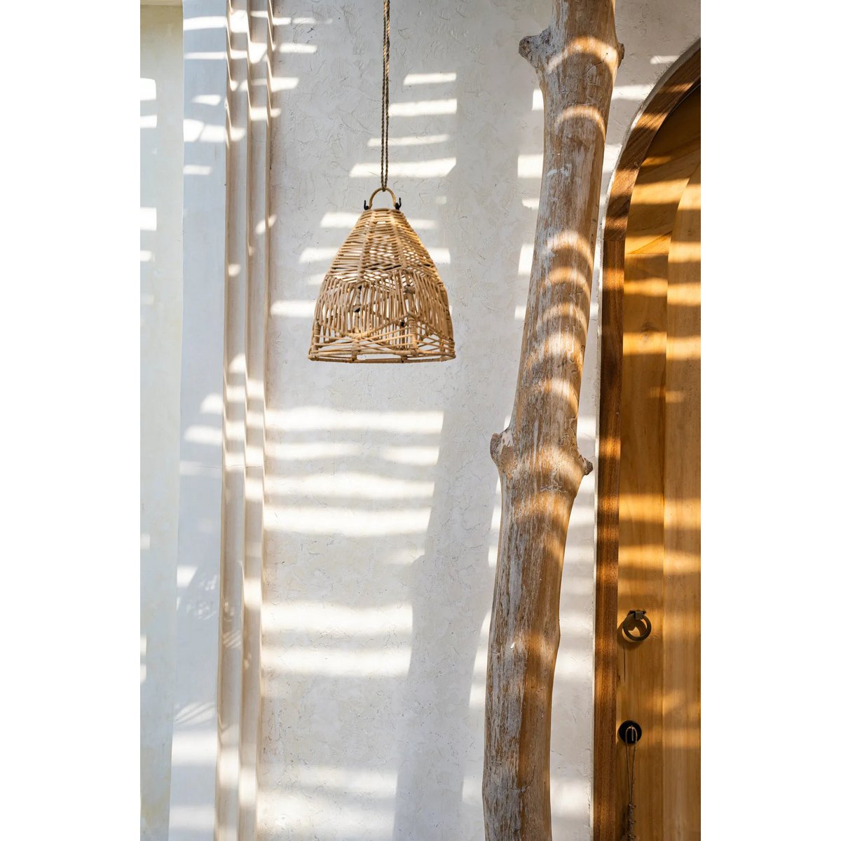 Rotan hanglamp Bulu Ayu boho stijl onder boom bij entree
