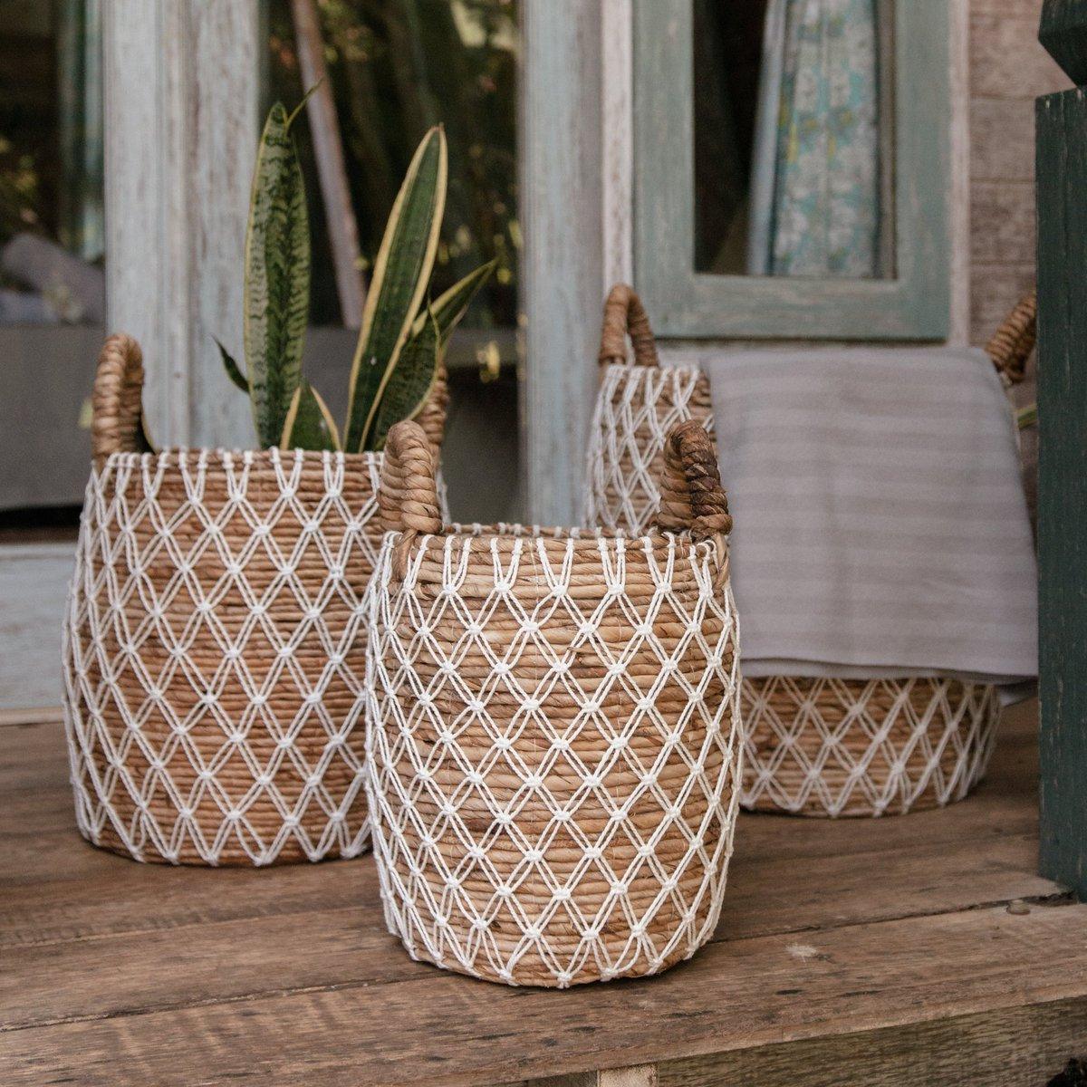 Drie Bumi Manden van bananenvezel bij een houten raamkozijn, met plant en plaid gestyled in boho sfeer voor binnen of buiten.