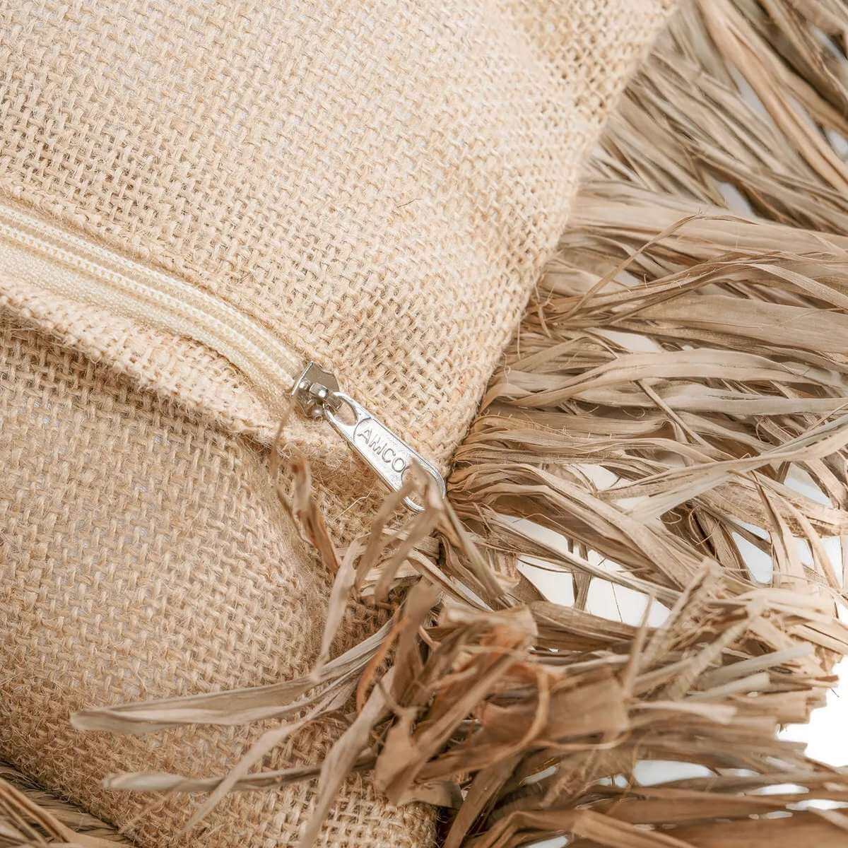 Detail van kussenhoes met ritssluiting en raffia franjes, close-up van de afwerking