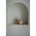 Stoneman beeldjes uit Sumba in een nis, gestyled in minimalistisch interieur