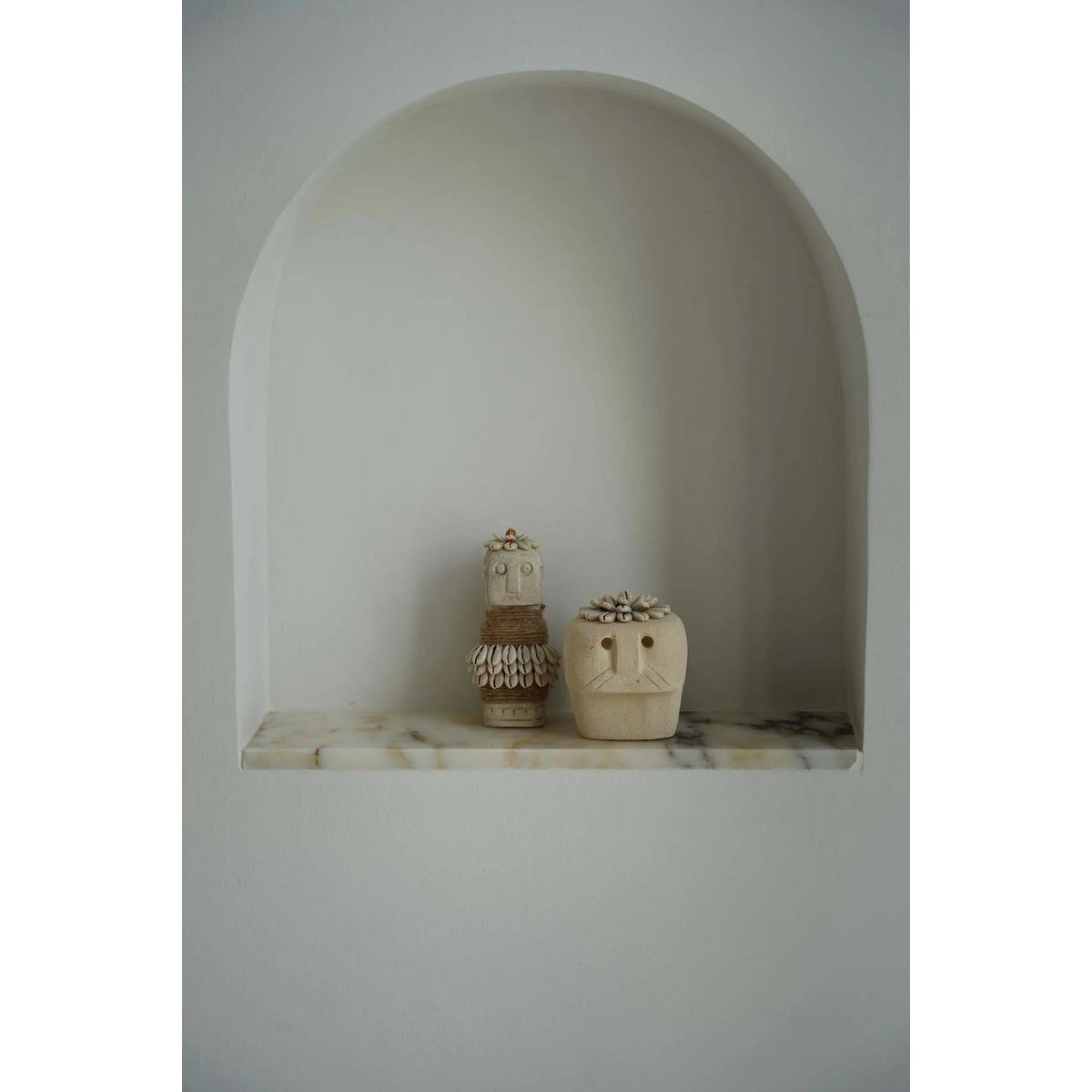 Stoneman beeldjes uit Sumba in een nis, gestyled in minimalistisch interieur