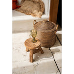 Handgemaakte Java rotan mand met deksel naast houten krukje – natuurlijk en decoratief