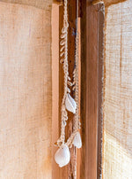 kauri schelpenketting als boho decoratie tussen linnen gordijnen en houten raamstijl