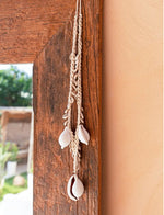 boho kauri ketting als wanddecoratie aan houten spiegelrand
