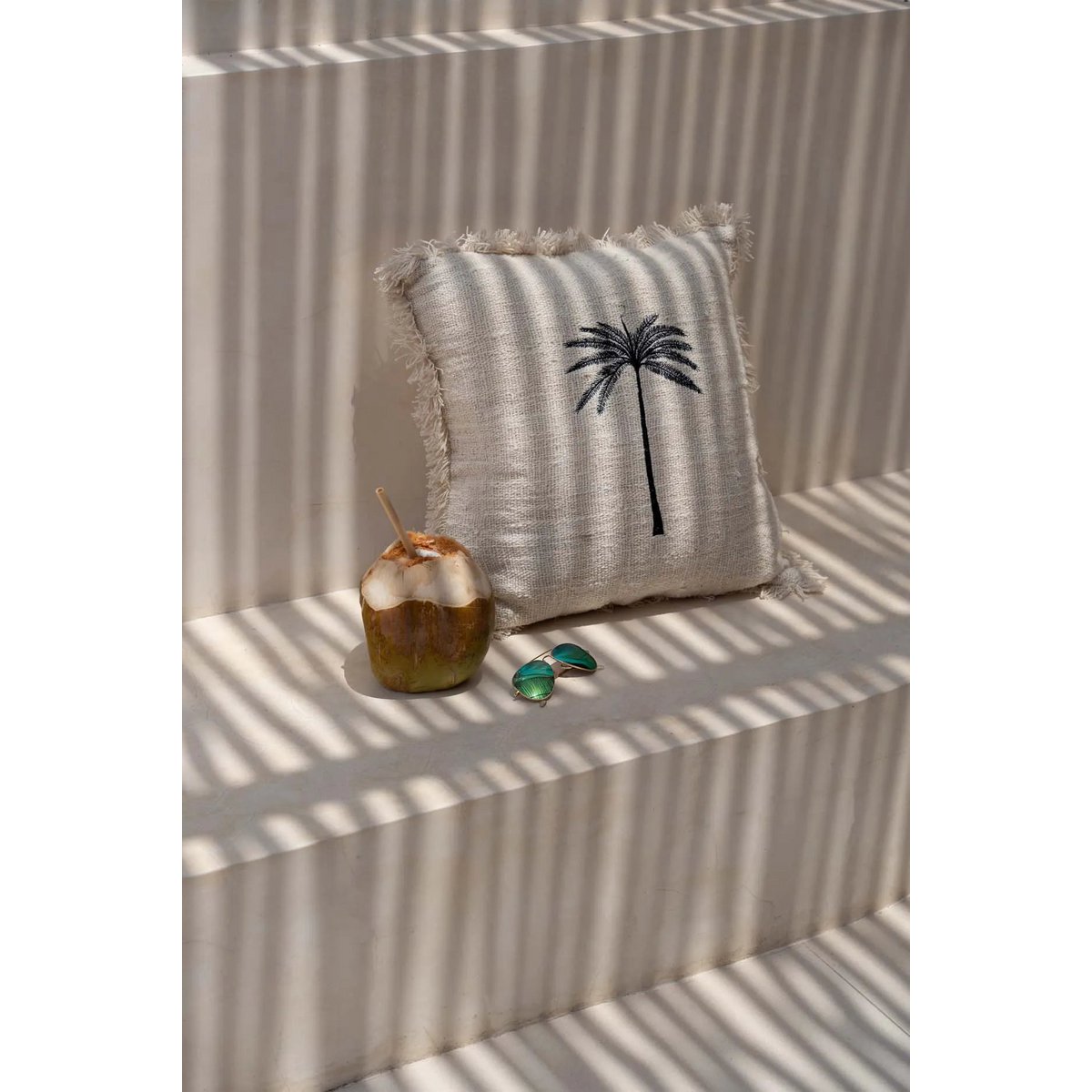Laguna Palm Kussenhoes met een kokosnoot en zonnebril in een zonovergoten setting