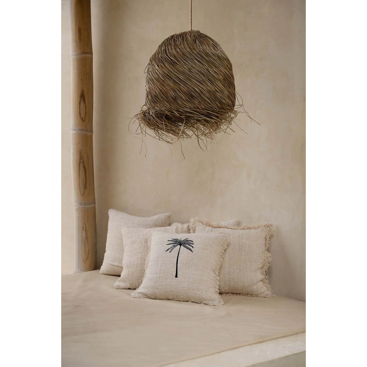 Laguna Palm Kussenhoes in een rustige setting met een natuurlijke lamp en meerdere kussens