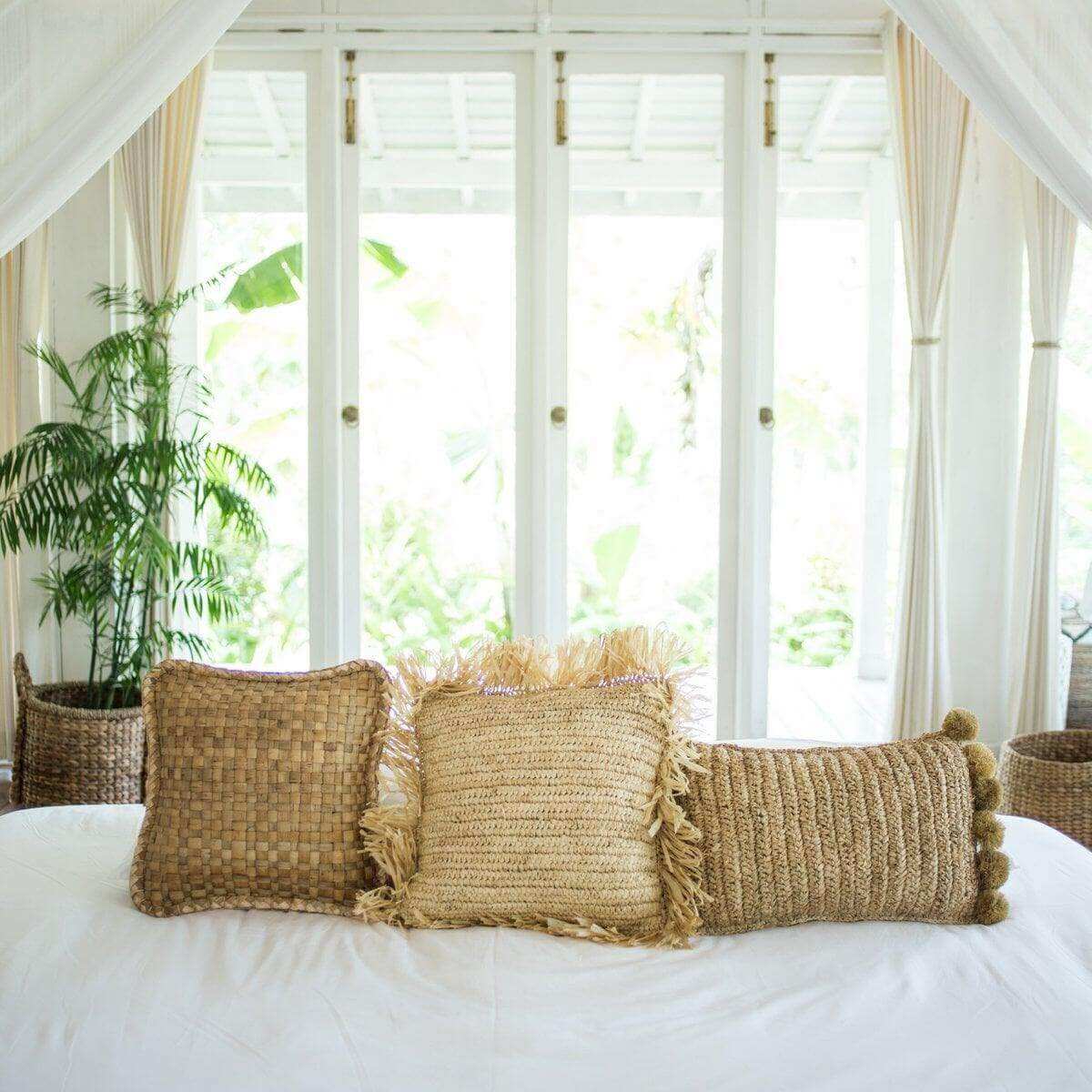 Boho raffia kussen met pompons gecombineerd met andere duurzame kussens