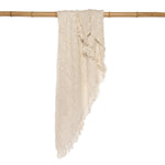 Safi Deken hangend over bamboe stok, beige boho deken met franjes.