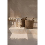 Beige Safiya Sprei met franjes gedrapeerd over opbergmand – Boho decoratie.