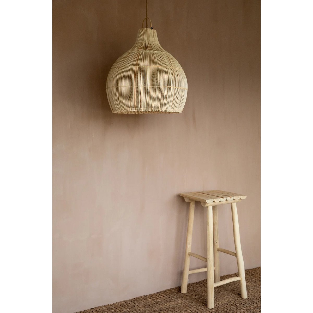 Solei Lume rotan hanglamp in boho interieur, een stijlvolle toevoeging boven een houten kruk