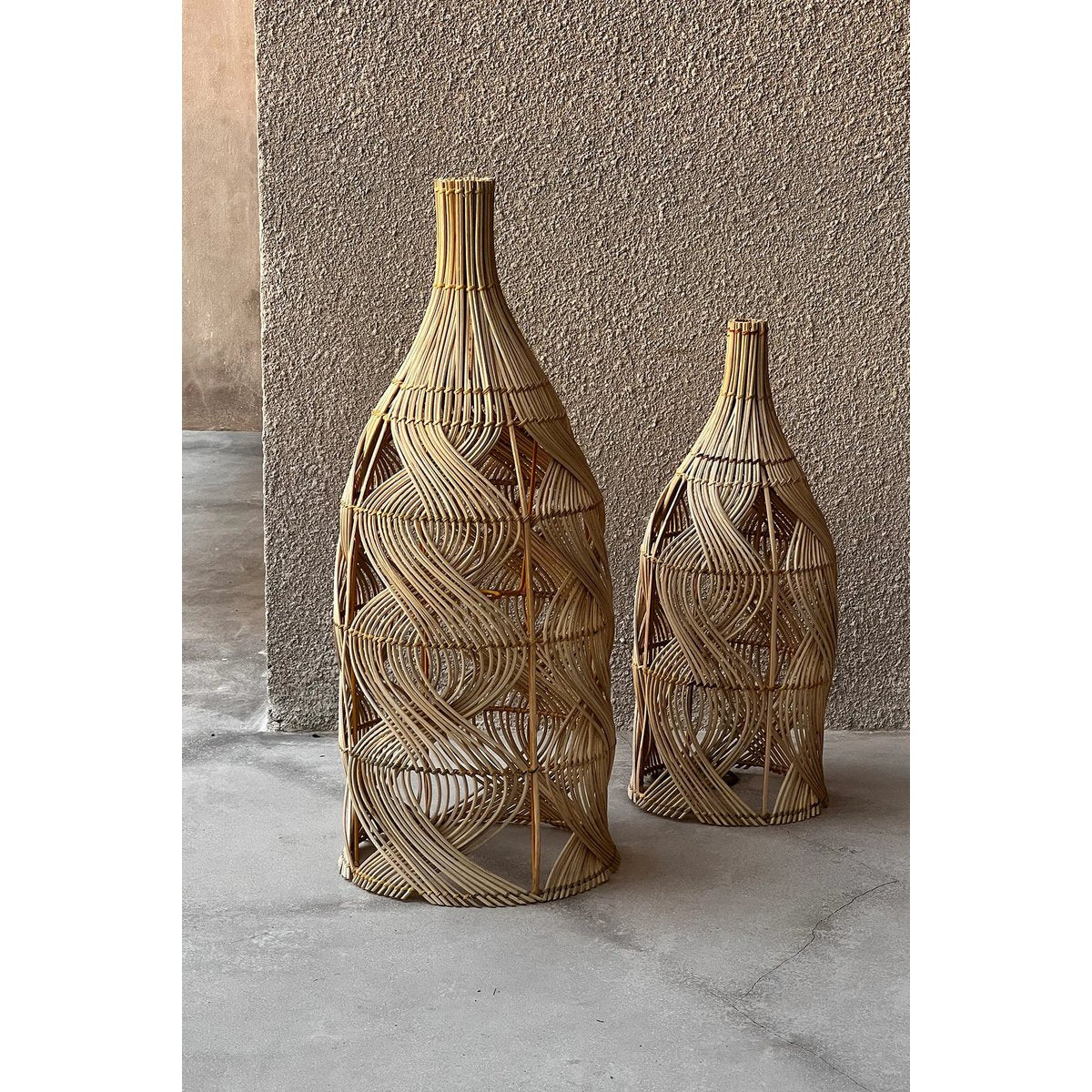 Zahara rotan lampen in maat M en L als decoratief sfeerbeeld tegen een buitenmuur in bohemian stijl